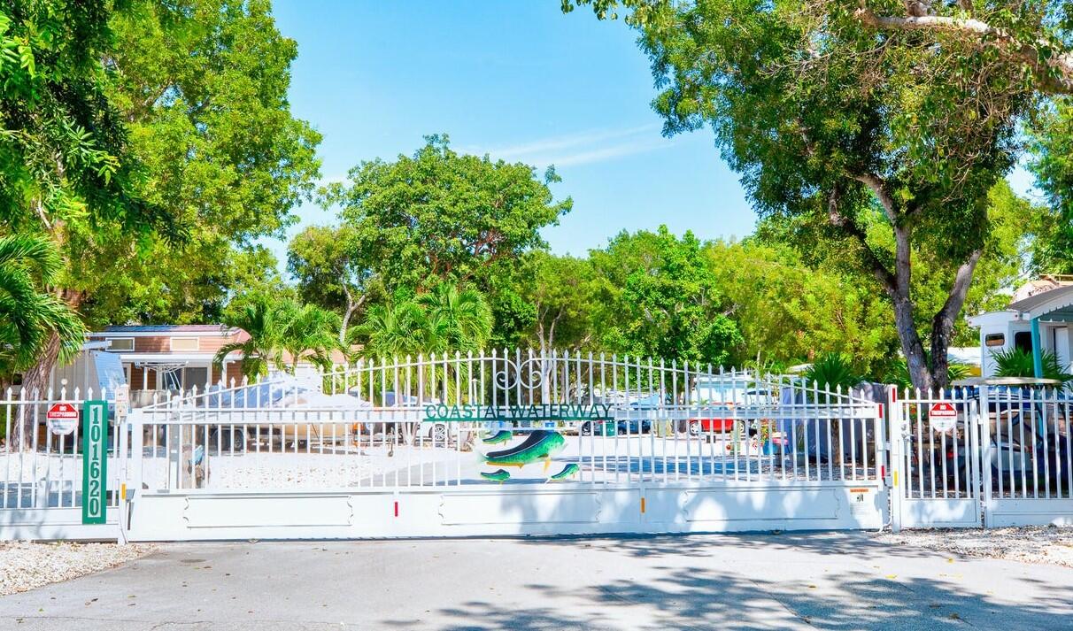 101620 Overseas Highway, Unit 5N Key Largo, FL 33037 - Photo 20 of 28 a view of a deck with a small yard and large trees