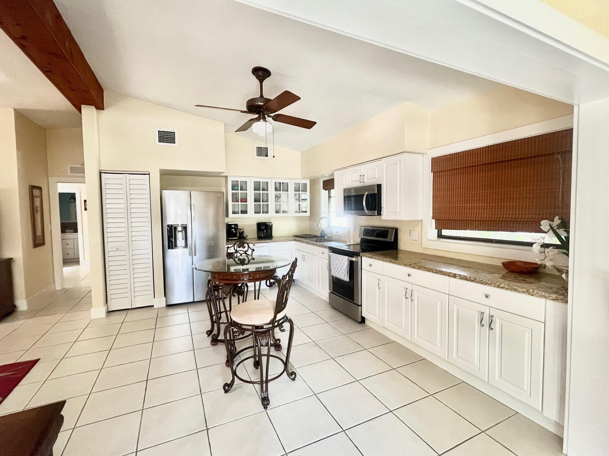 101620 Overseas Highway, Unit 5N Key Largo, FL 33037 - Photo 6 of 28 a kitchen with stainless steel appliances kitchen island granite countertop a sink and cabinets
