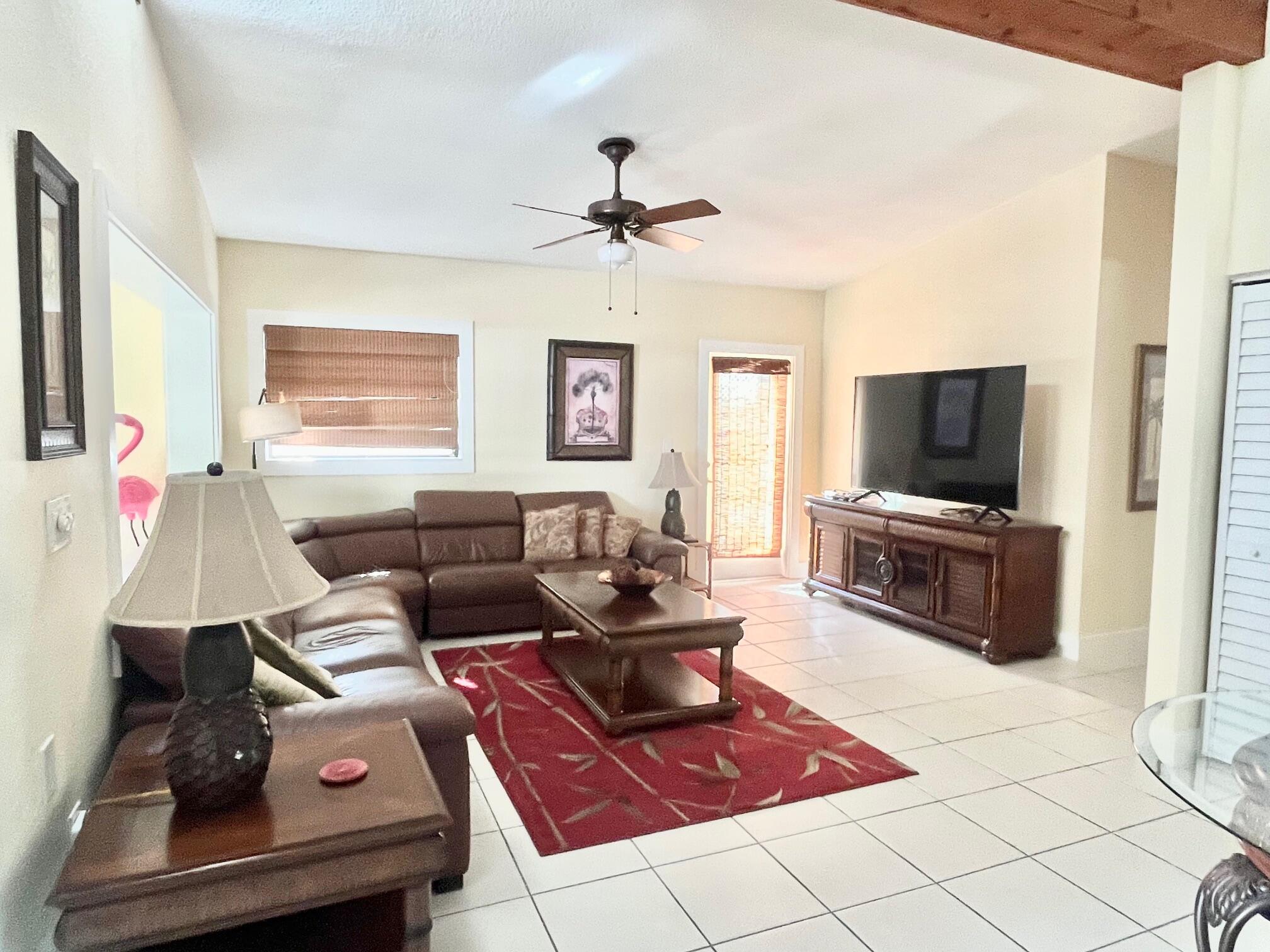 101620 Overseas Highway, Unit 5N Key Largo, FL 33037 - Photo 8 of 28 a living room with furniture and a flat screen tv