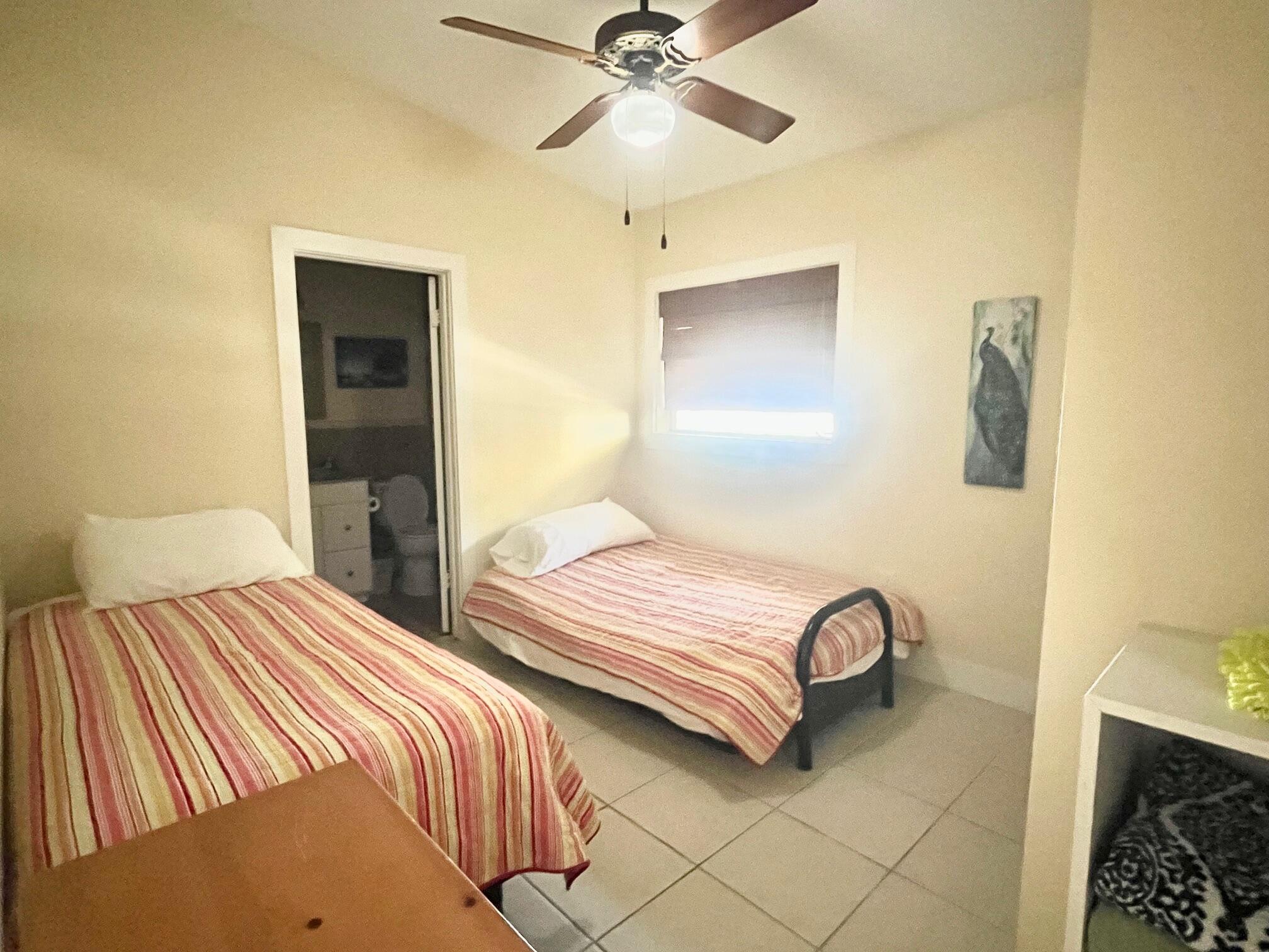 101620 Overseas Highway, Unit 5N Key Largo, FL 33037 - Photo 10 of 28 a bedroom with two beds and painted walls