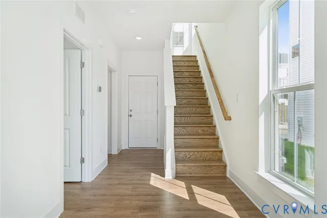 a view of a hallway with wooden floor and windows