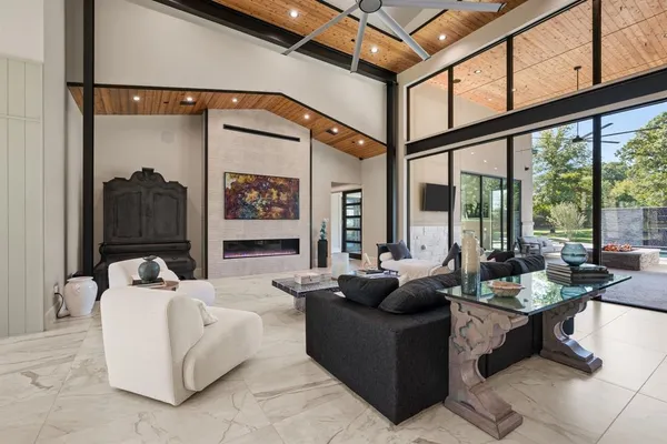 a living room with fireplace furniture and a large window