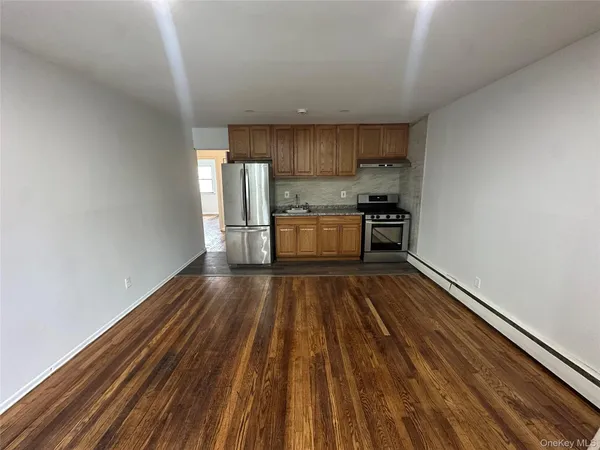 a kitchen with wooden floors and stainless steel appliances