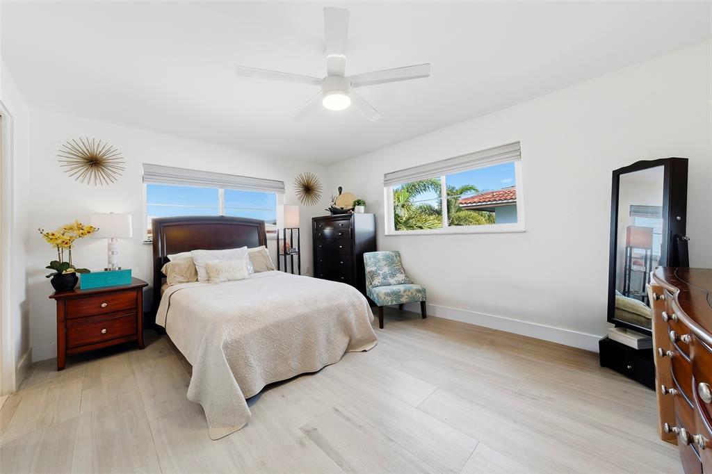 1450 North Riverside Drive, Unit 201 Pompano Beach, FL 33062 - Photo 11 of 30 a bedroom with a bed and a flat tv screen on dresser