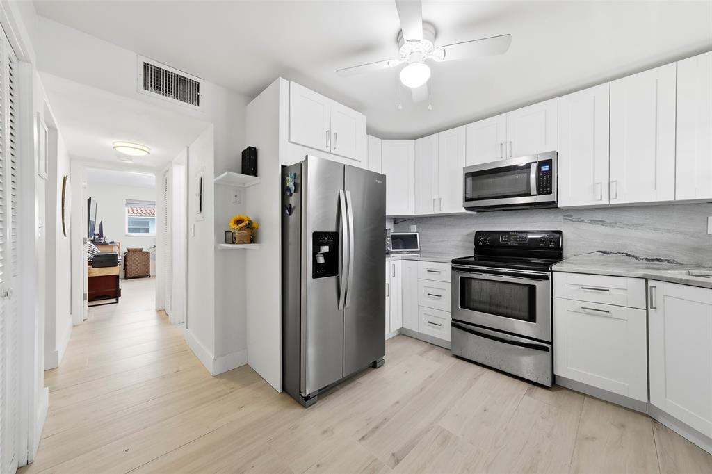 1450 North Riverside Drive, Unit 201 Pompano Beach, FL 33062 - Photo 18 of 30 a kitchen with stainless steel appliances a refrigerator stove and microwave