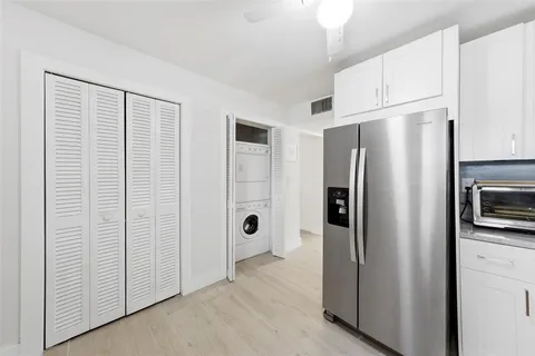a view of a kitchen with refrigerator stove and cabinets