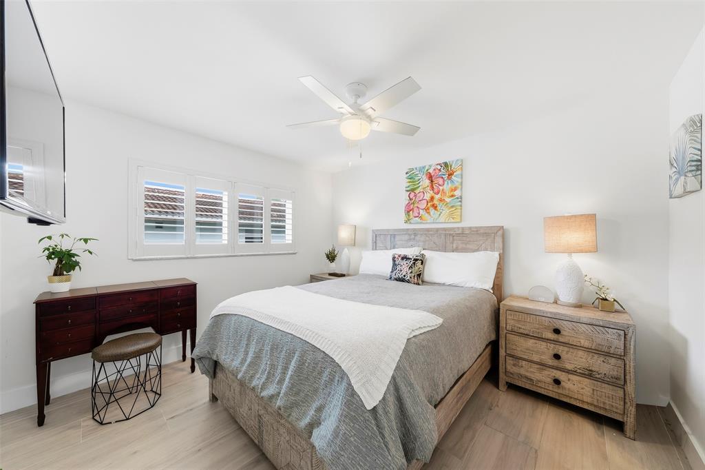 1450 North Riverside Drive, Unit 201 Pompano Beach, FL 33062 - Photo 8 of 30 a bedroom with a bed and a chandelier