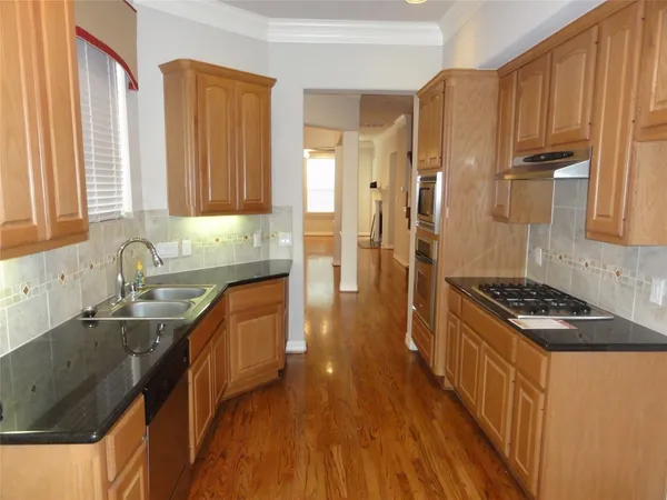 a kitchen with granite countertop a sink a stove and refrigerator