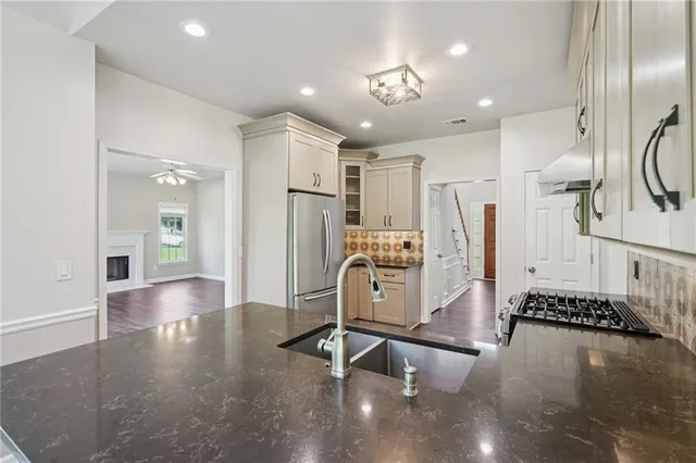 a view of a kitchen with refrigerator and wooden floor