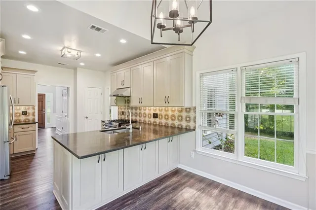 a kitchen with stainless steel appliances granite countertop a sink and refrigerator