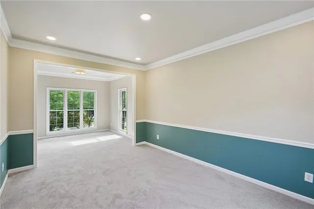 an empty room with large windows and a ceiling fan