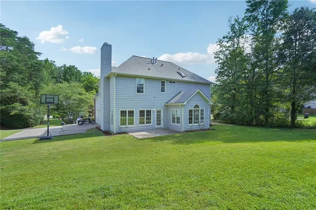 a front view of a house with a yard and trees