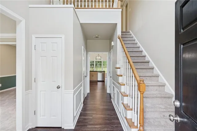 a view of a hallway with wooden floor and staircase