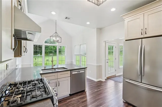 a open kitchen with stainless steel appliances granite countertop a stove and a refrigerator