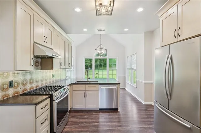 a kitchen with stainless steel appliances granite countertop a sink stove and refrigerator