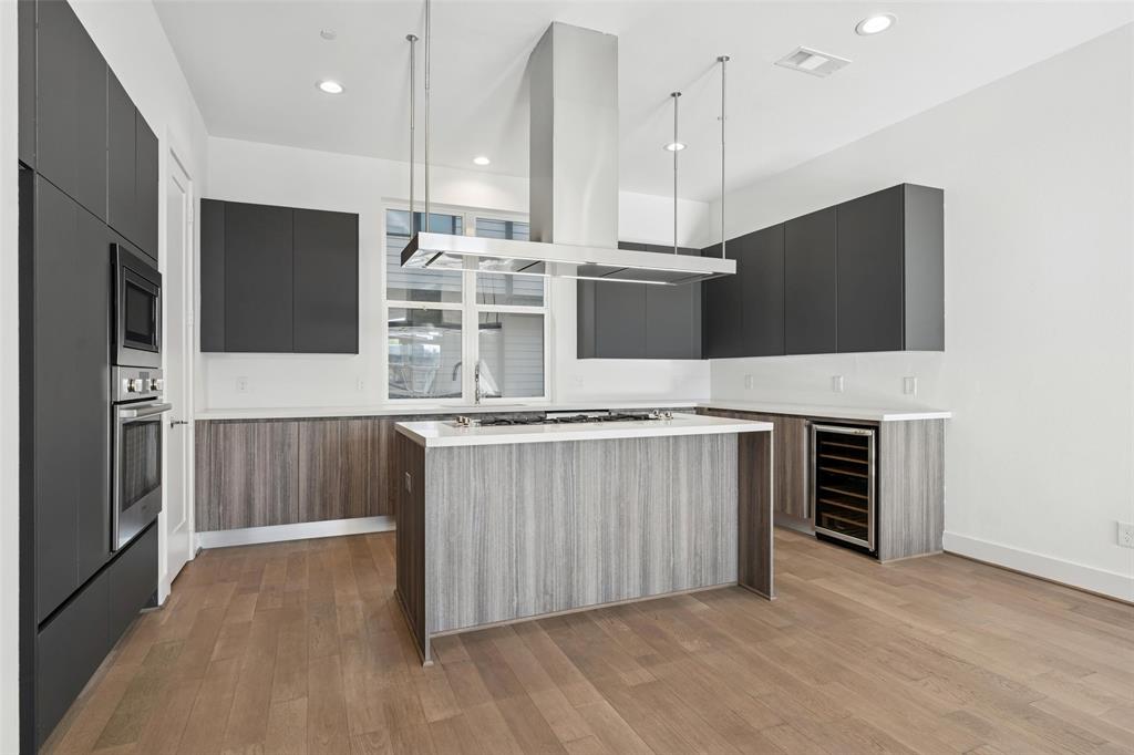 3040 ChImes Street Dallas, TX 75219 - Photo 11 of 38 a kitchen with stainless steel appliances a refrigerator and a fireplace