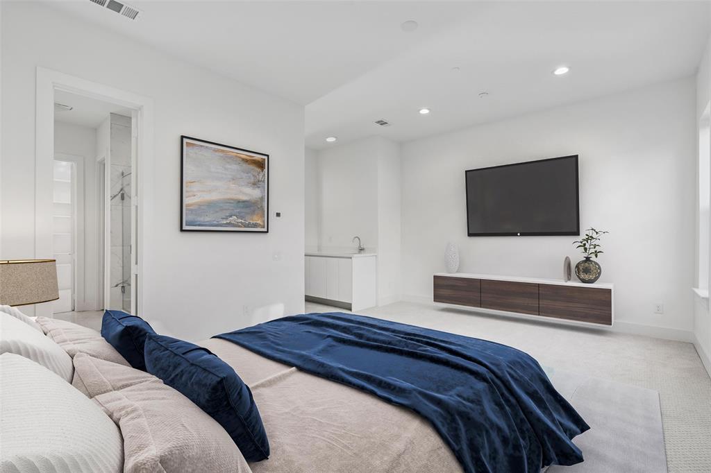 3040 ChImes Street Dallas, TX 75219 - Photo 14 of 38 a bedroom with a bed and a flat screen tv