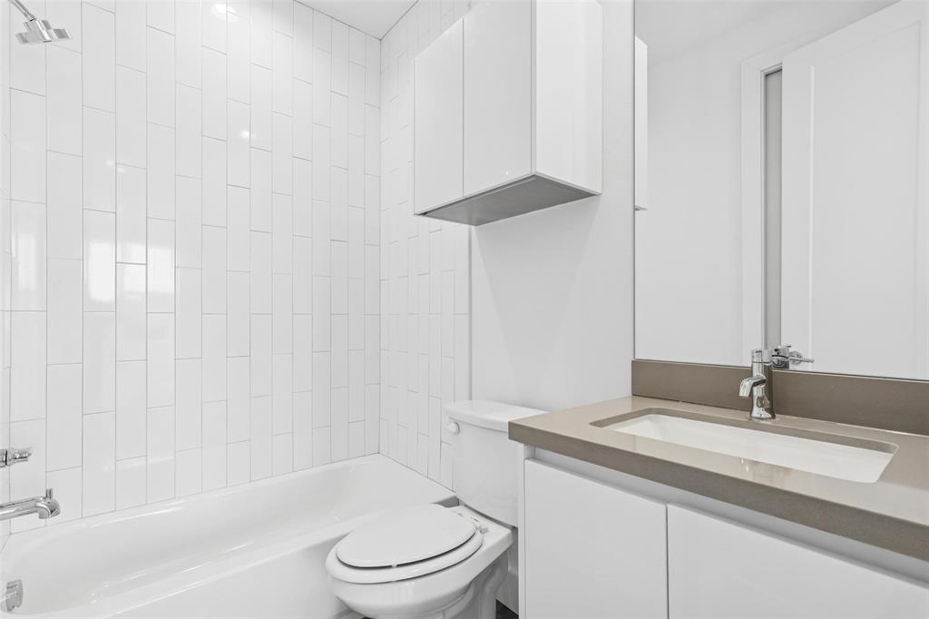 3040 ChImes Street Dallas, TX 75219 - Photo 26 of 38 a bathroom with a granite countertop sink a toilet and bathtub
