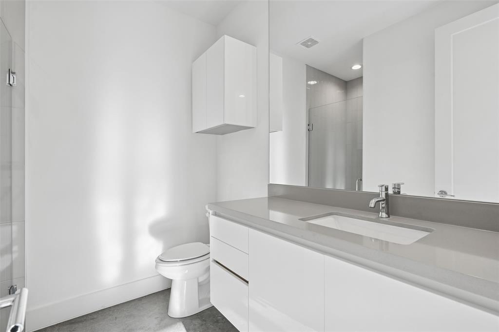 3040 ChImes Street Dallas, TX 75219 - Photo 28 of 38 a bathroom with a granite countertop sink a toilet and a mirror