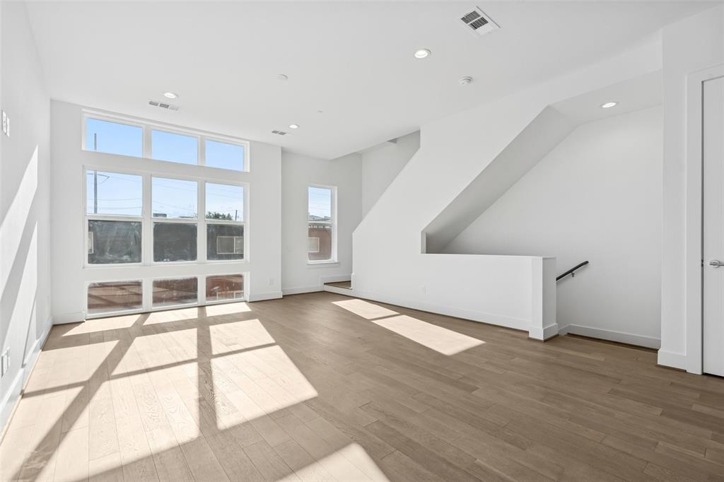 3040 ChImes Street Dallas, TX 75219 - Photo 7 of 38 a view of an empty room with wooden floor and a window