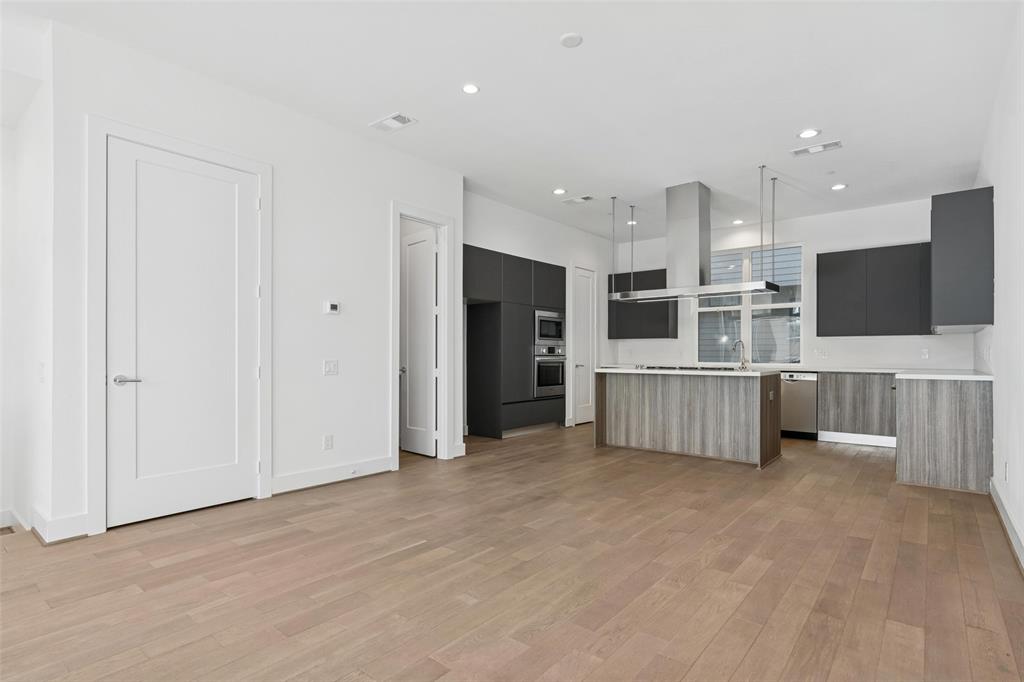 3040 ChImes Street Dallas, TX 75219 - Photo 8 of 38 a view of a kitchen with stainless steel appliances kitchen island large and wooden floor