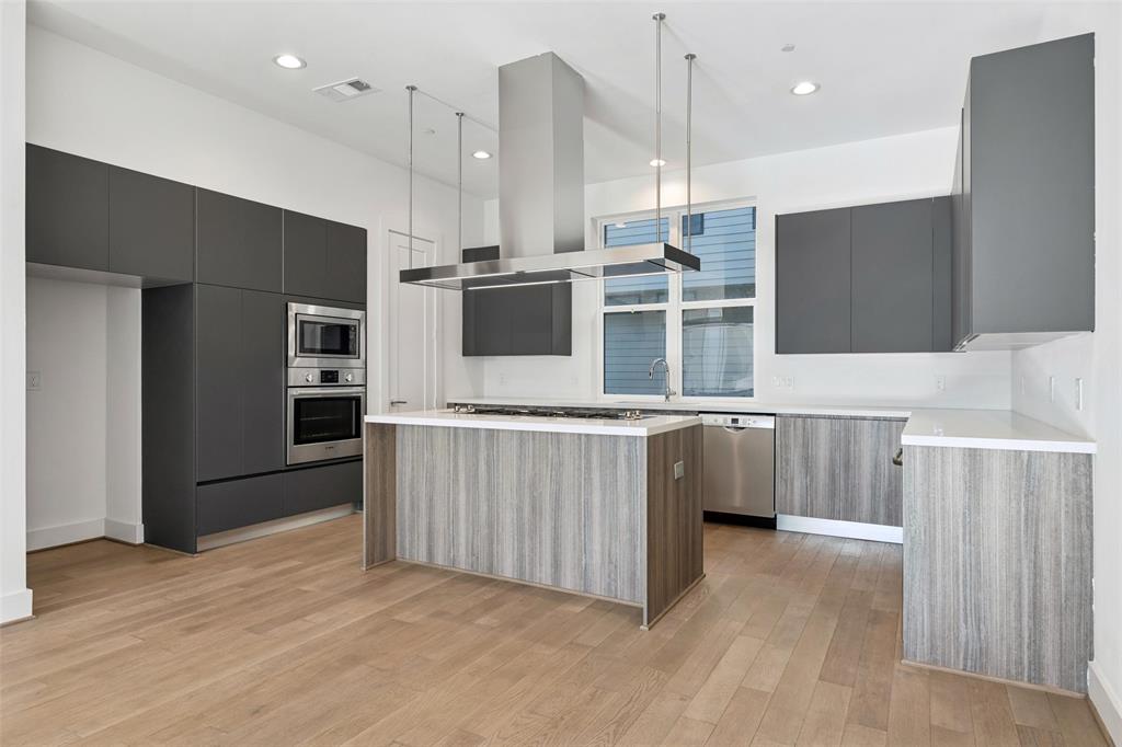 3040 ChImes Street Dallas, TX 75219 - Photo 10 of 38 a kitchen with stainless steel appliances a refrigerator and a wooden floor