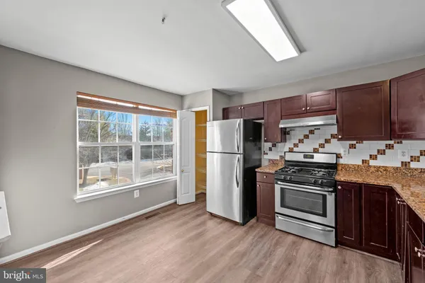 a kitchen with stainless steel appliances a stove a sink and a refrigerator
