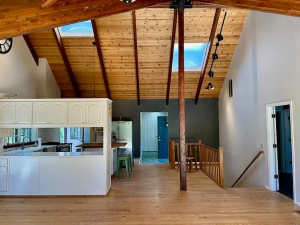 a view of a hall with a window and wooden floor