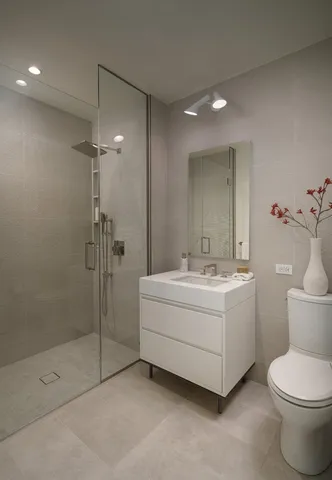 a bathroom with a sink a toilet and shower