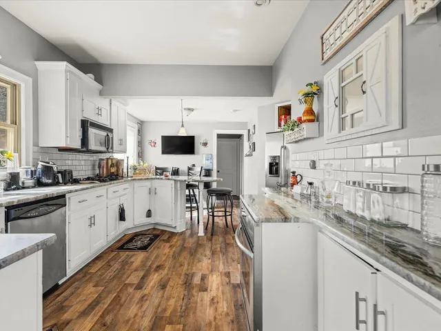 a kitchen with stainless steel appliances kitchen island granite countertop a sink and cabinets