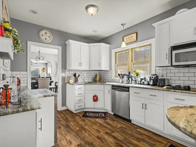 a kitchen with granite countertop a sink stainless steel appliances and cabinets