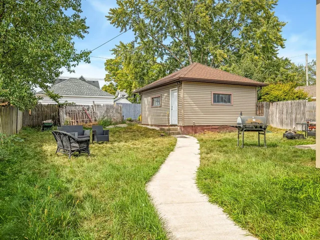 a backyard of a house with table and chairs