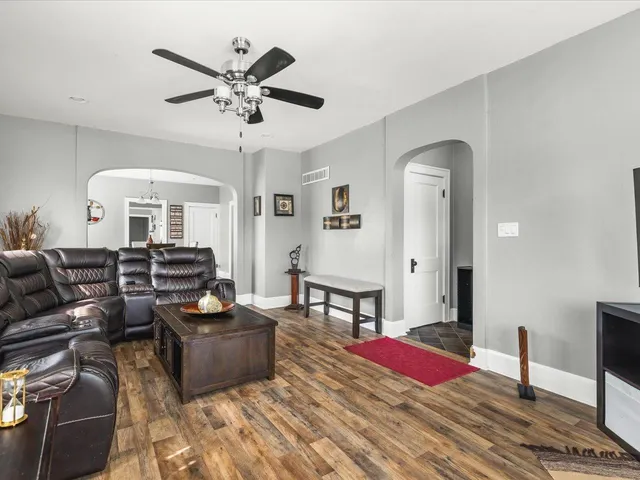 a living room with furniture a rug and wooden floor