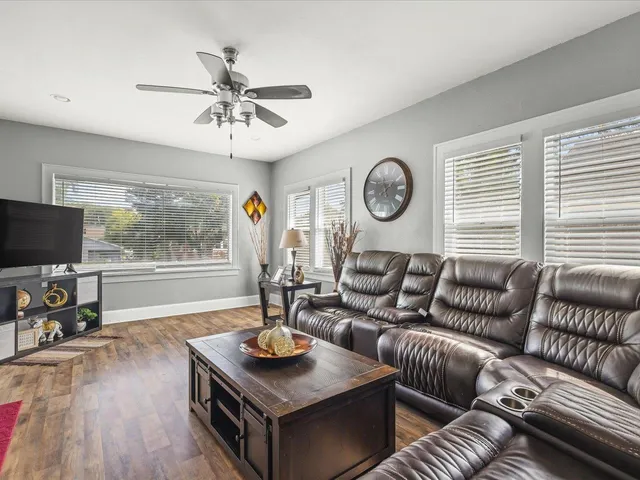 a living room with furniture a flat screen tv and a large window