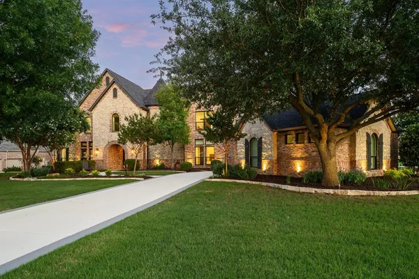 a front view of a house with a yard and trees