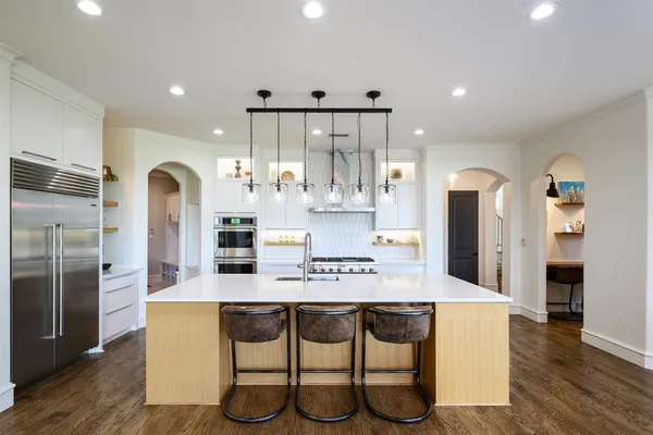 a large kitchen with kitchen island a large window in it