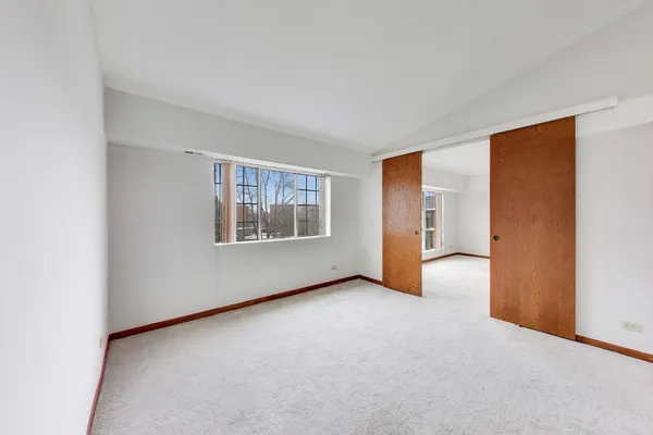 an empty room with windows and closet