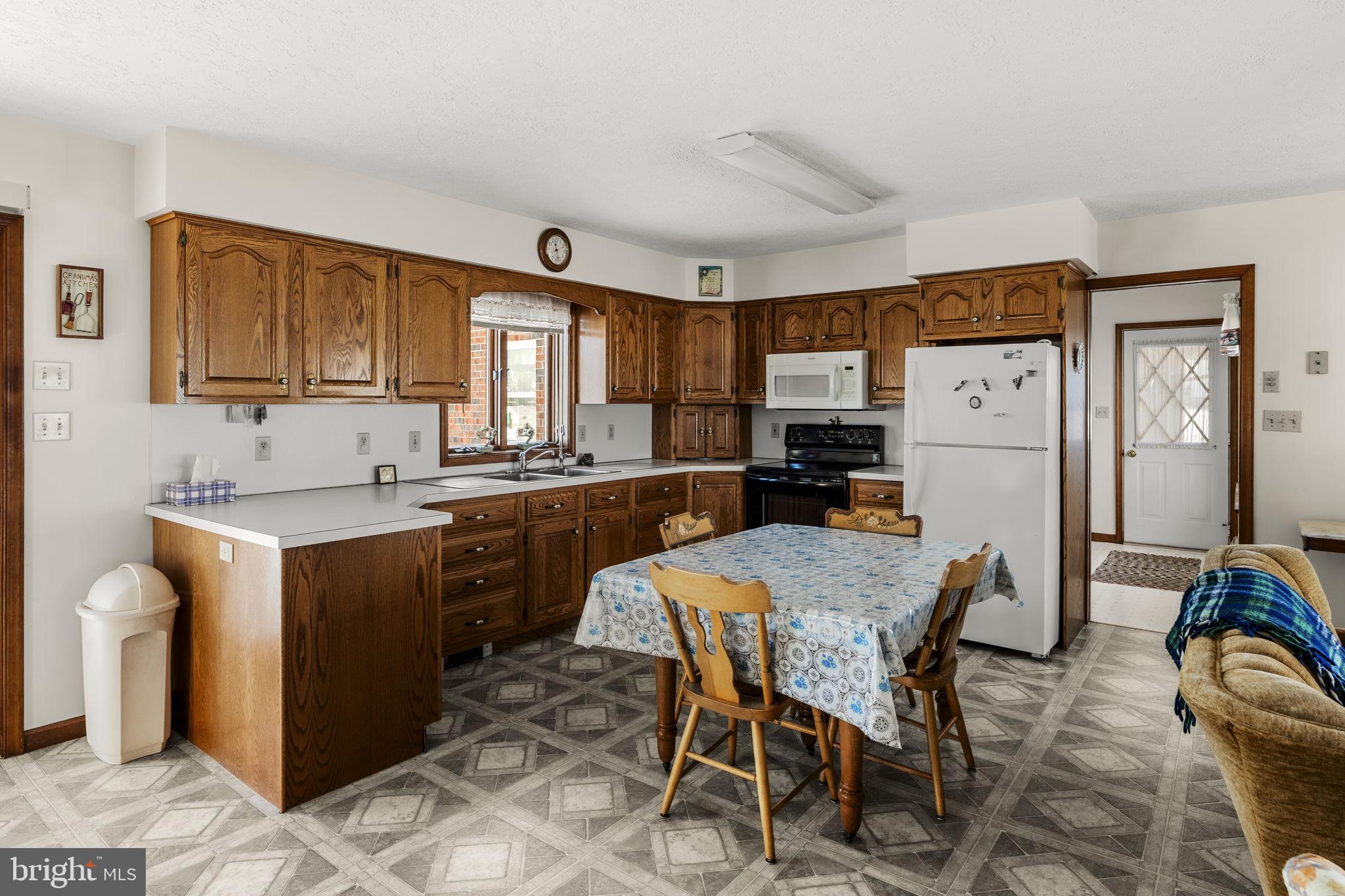 85 Wissler Road Lititz, PA 17543 - Photo 23 of 58 a kitchen with granite countertop a refrigerator a stove a sink dishwasher and white cabinets with wooden floor