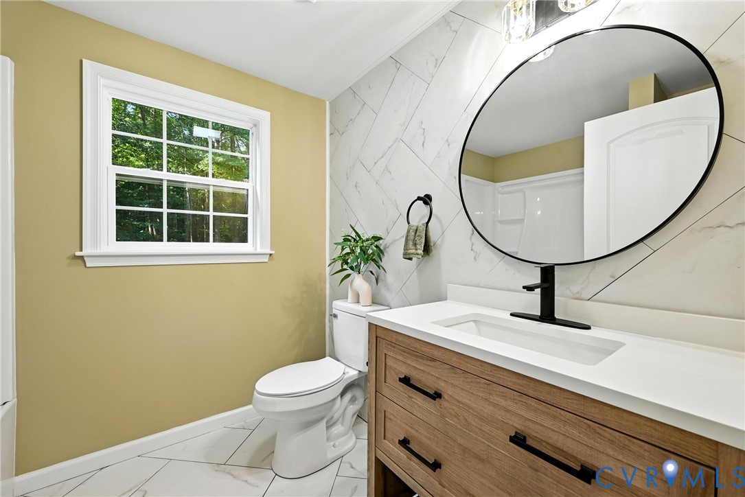 24611 Williamson Road Dinwiddie, VA 23841 - Photo 13 of 34 Bathroom with vanity, tile walls, and marble look