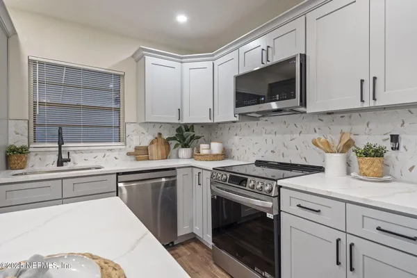a kitchen with stainless steel appliances granite countertop a sink and a stove top oven