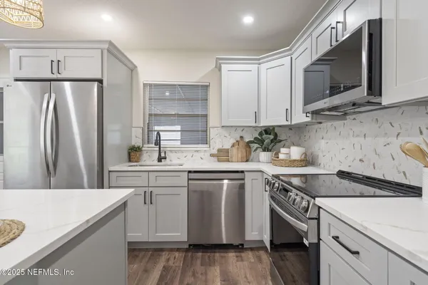 a kitchen with stainless steel appliances granite countertop a refrigerator sink and microwave