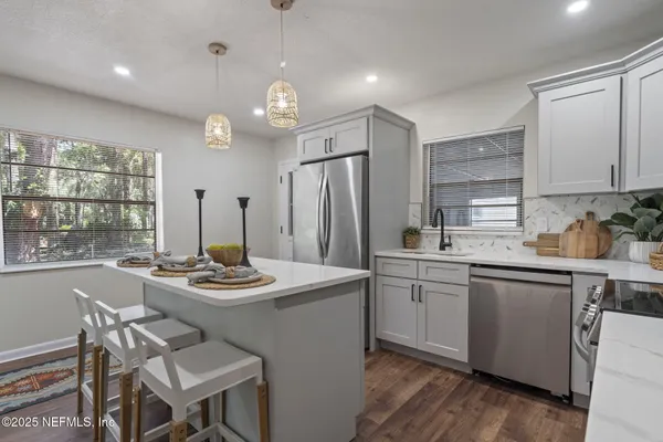 a kitchen with a table chairs stove and refrigerator
