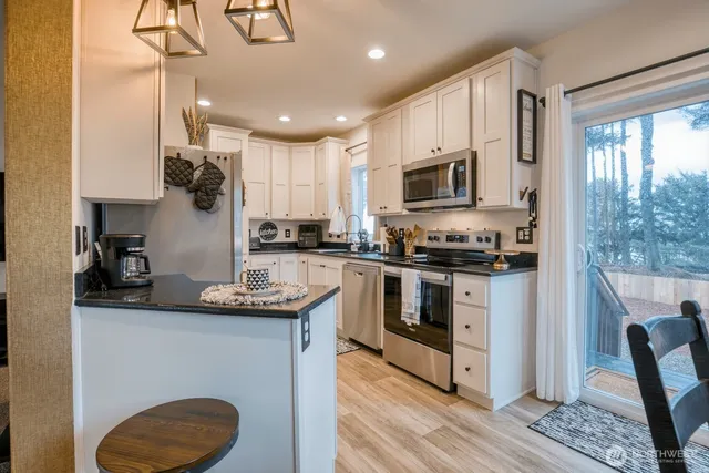 a kitchen with stainless steel appliances granite countertop a sink stove microwave and refrigerator