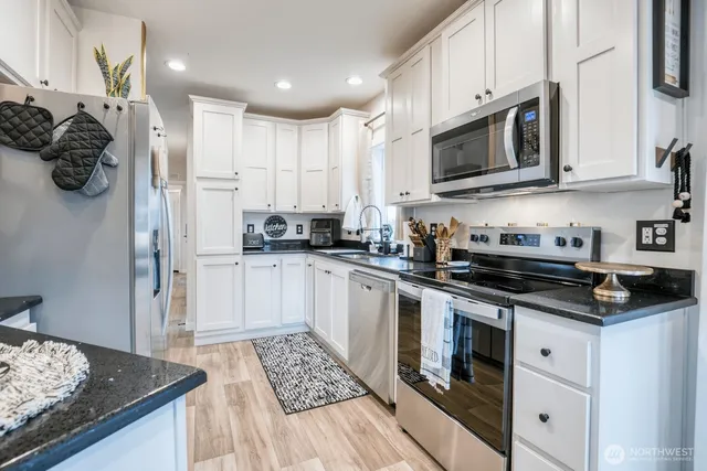 a kitchen with stainless steel appliances granite countertop a stove a sink and a microwave