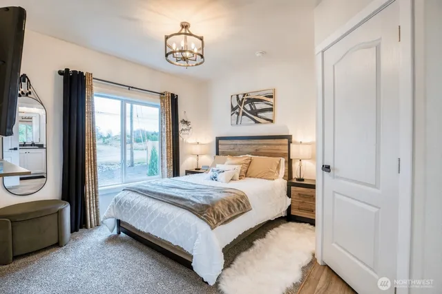 a bedroom with a large bed and a chandelier