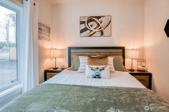 a bedroom with a bed and wooden floor