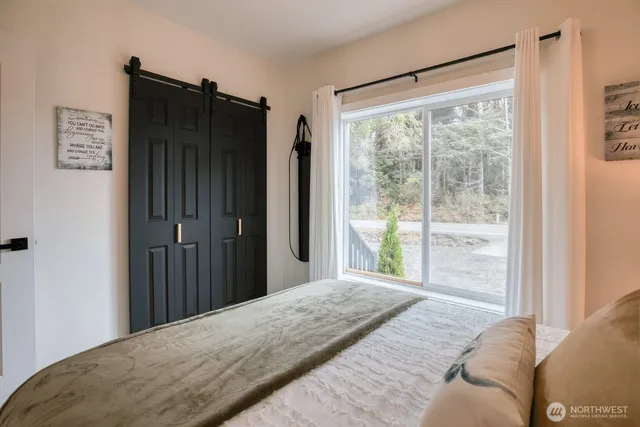 a bedroom with a bed and a large window