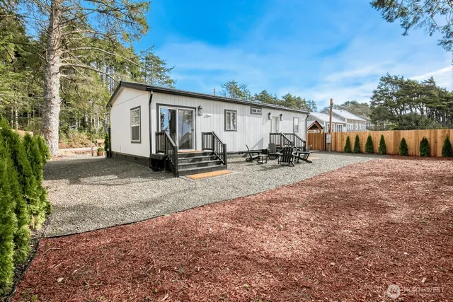 a view of a house with backyard and a trees