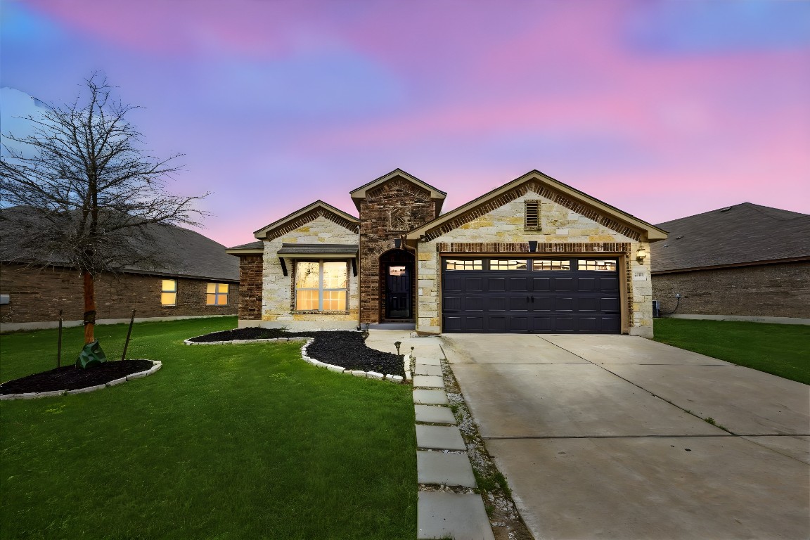 12413 Silverstream Lane Manor, TX 78653 - Photo 1 of 1 a front view of a house with a yard and garage