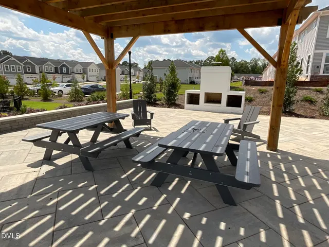 a view of a patio with dining table and chairs with wooden floor and fence